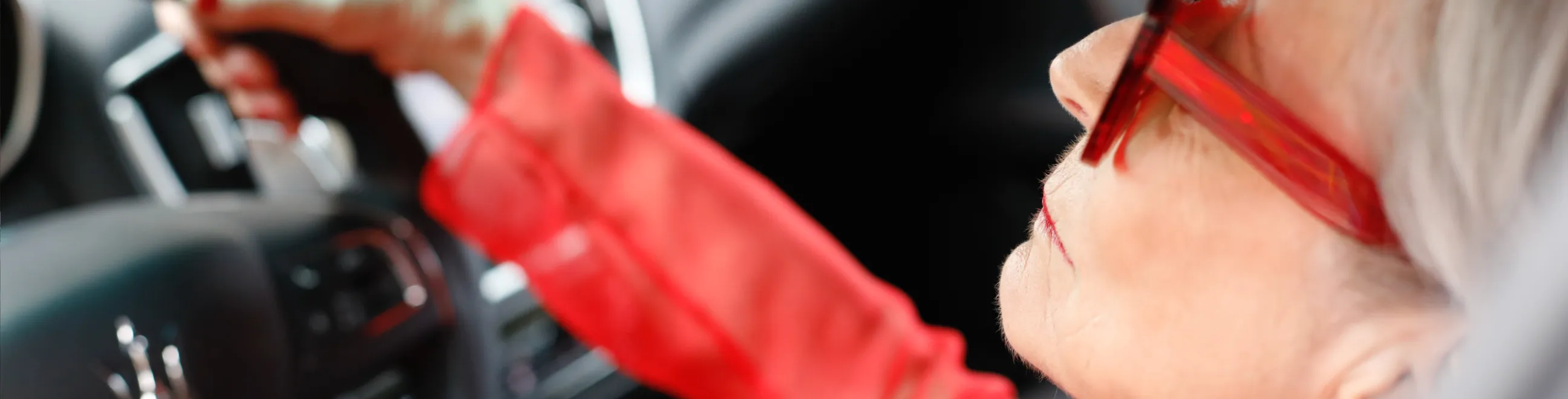 Dam i rött kör bil